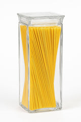 Clear acrylic jar filled with yellow spaghetti on a white background