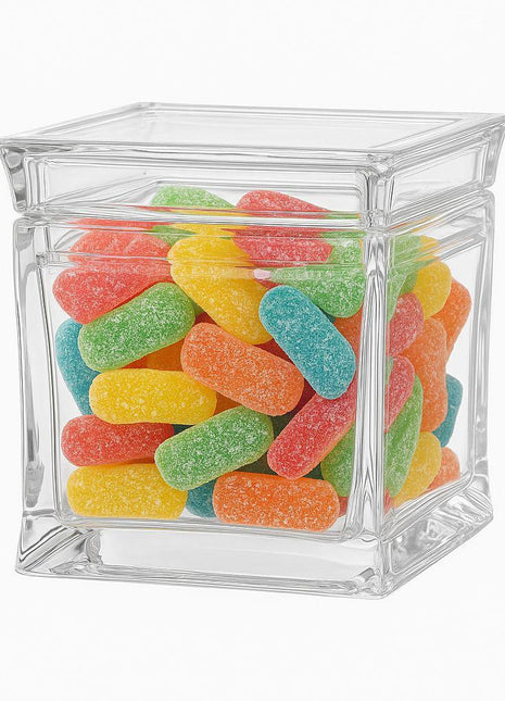 Clear glass jar filled with colorful gummy candies on a white background