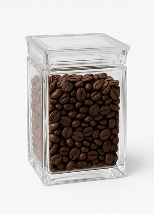 Clear acrylic jar filled with coffee beans on a white background